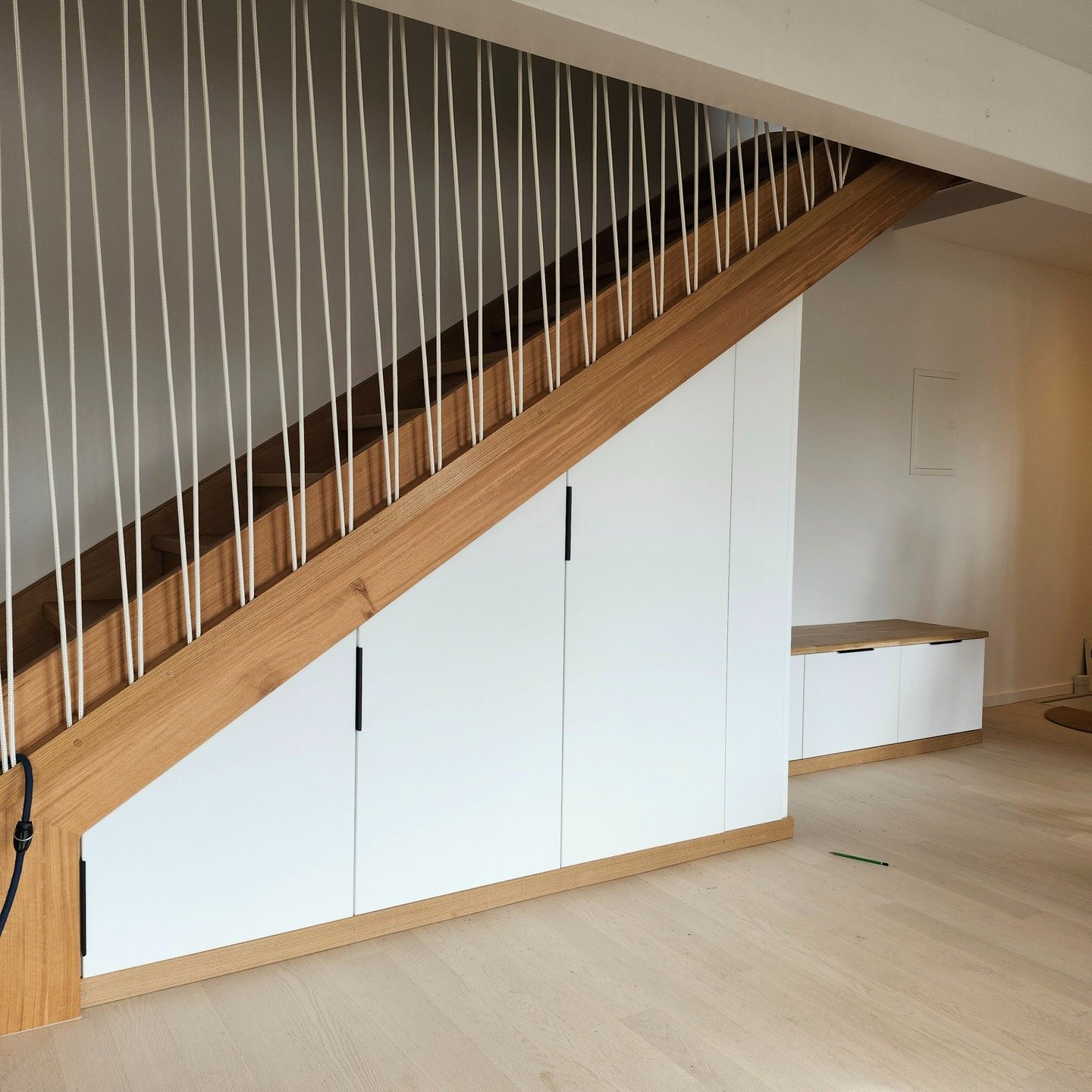 Escalier en bois avec rangements blancs sous l'escalier